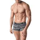 Man wearing plaid boxer shorts with black waistband featuring 'ANAIS' lettering.