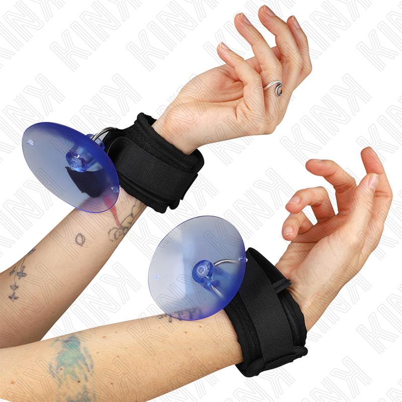 Close-up of hands wearing black wrist cuffs with blue disks, showcasing a unique bondage accessory from the SM & Bondage collection.