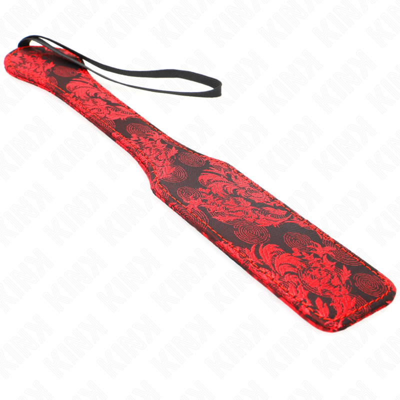 Red and black BDSM paddle with floral design and wrist strap for impact play.