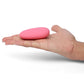 Pink pebble-shaped clit vibrator on hand showcasing its compact and smooth design for enhanced sensations.