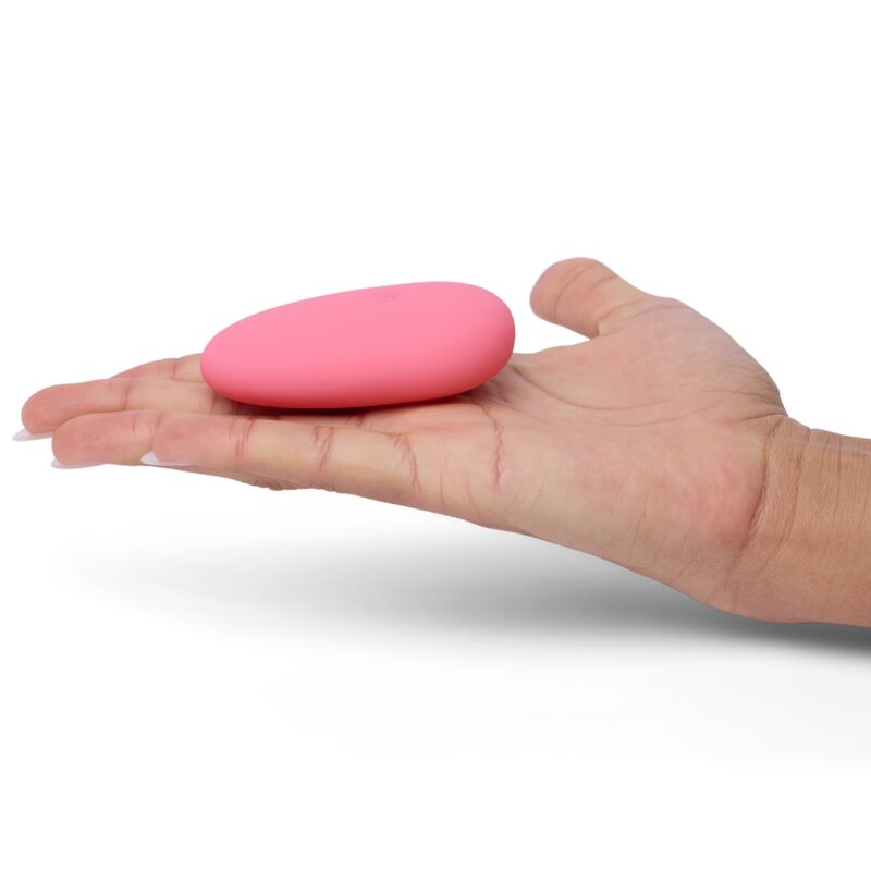 Pink pebble-shaped clit vibrator on hand showcasing its compact and smooth design for enhanced sensations.