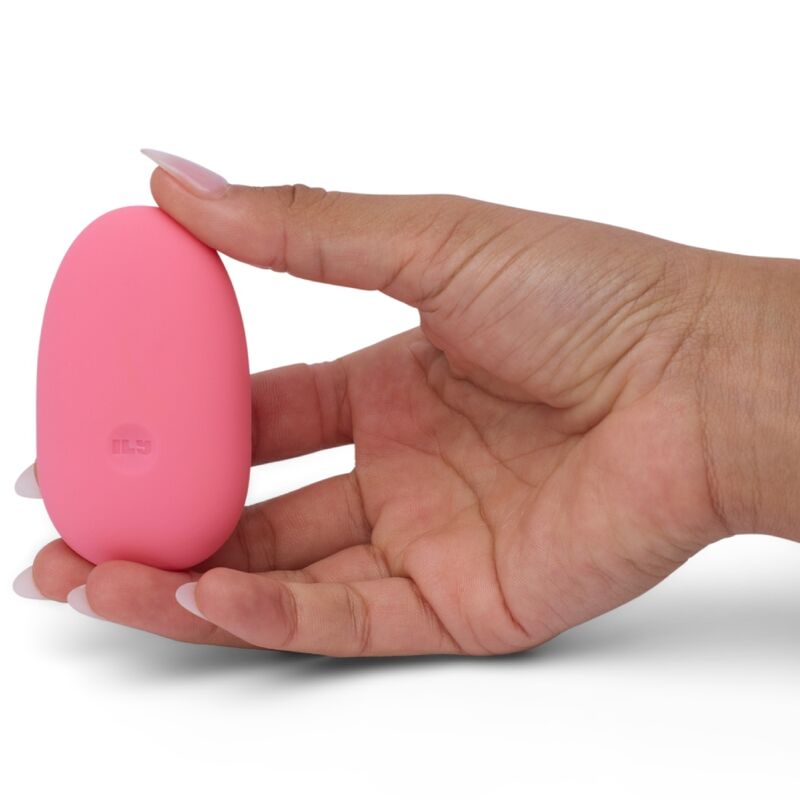 Hand holding pink Je Joue Pebble Clit Vibrator Stimulator, smooth design for enhanced pleasure and self-love sessions.